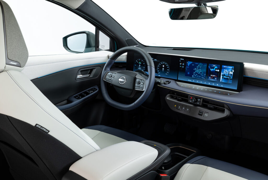 Tableau de bord de la Nissan Leaf 2025 avec écran tactile panoramique, volant multifonction et intérieur moderne.
