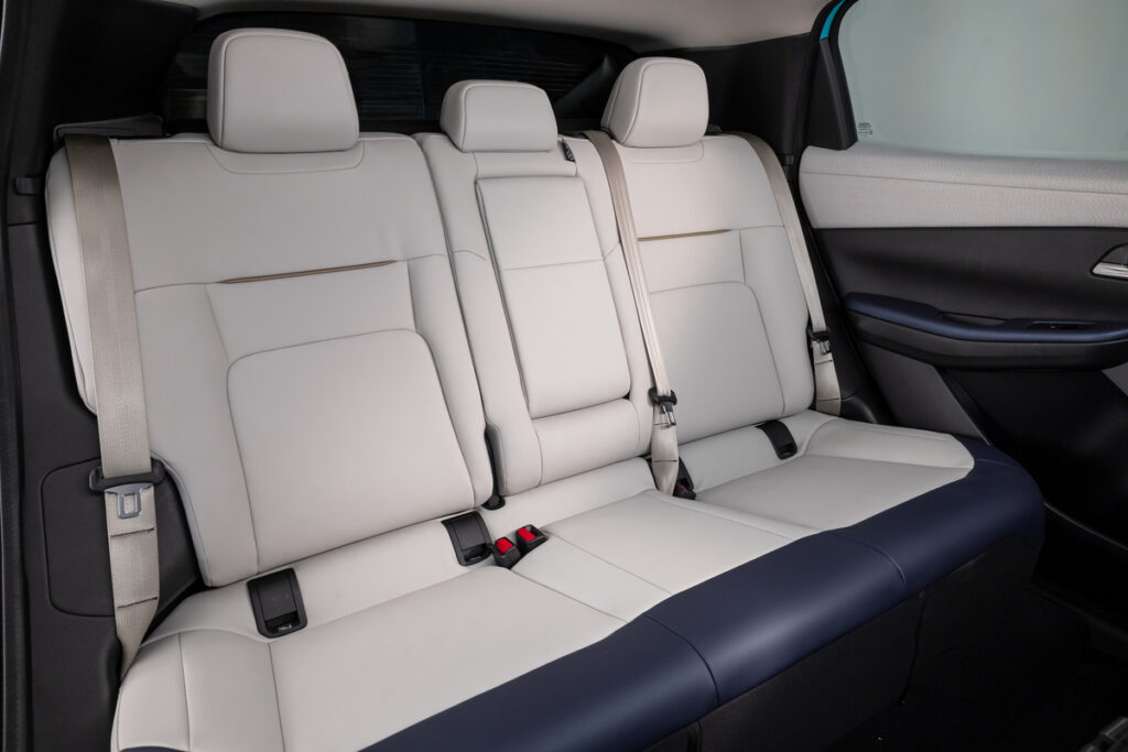 Vue de la banquette arrière de la Nissan Leaf 2025 avec sellerie claire et assise large pour trois passagers.