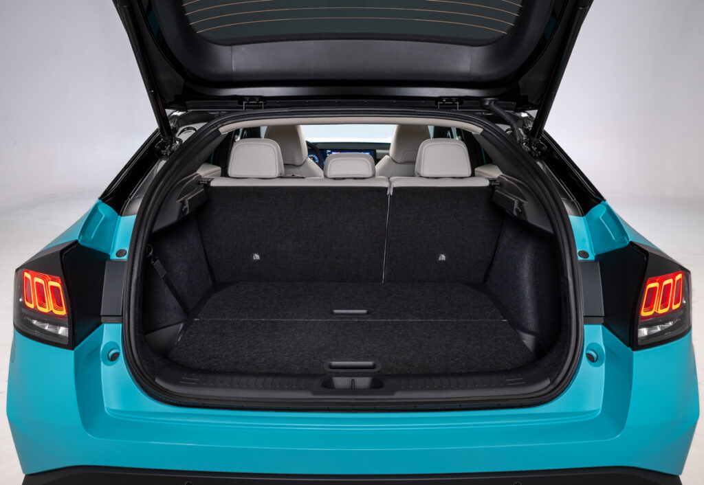 Coffre arrière ouvert de la Nissan Leaf 2025 montrant un grand espace de rangement avec sièges arrière en position verticale.